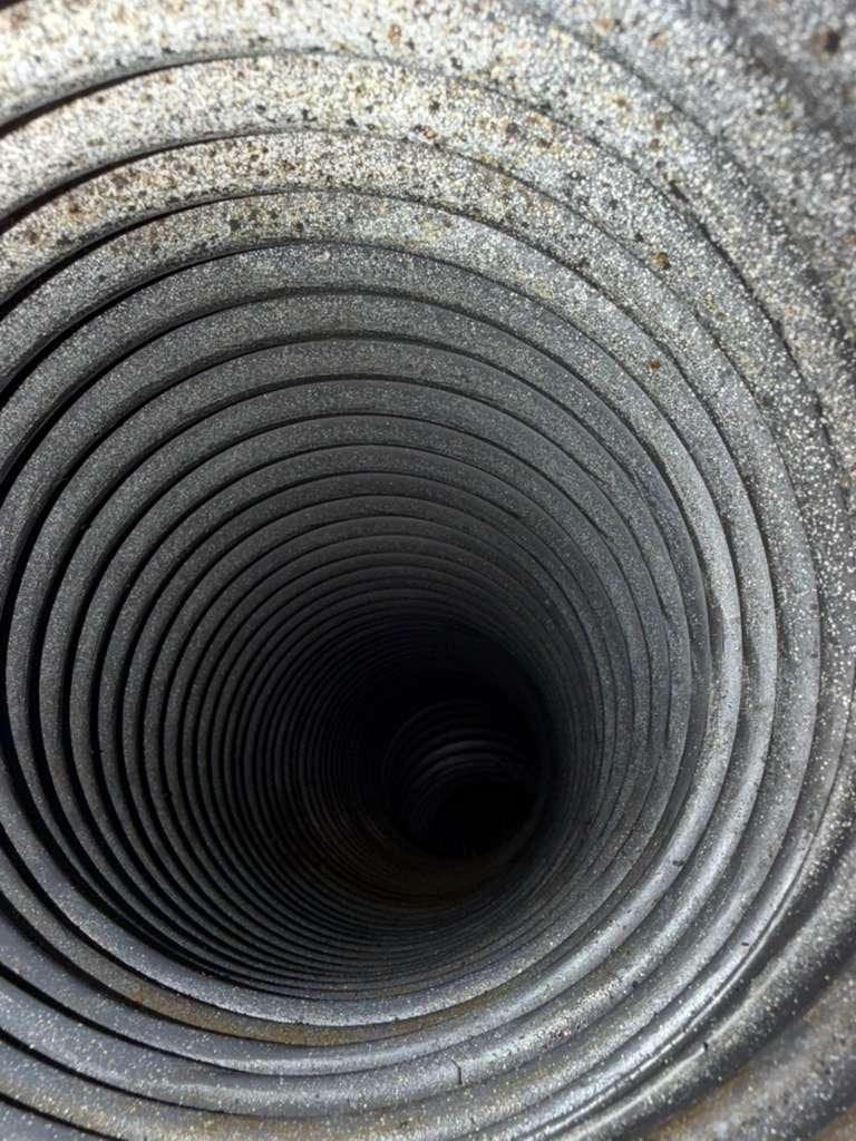Clean metal duct interior with a light dust pattern